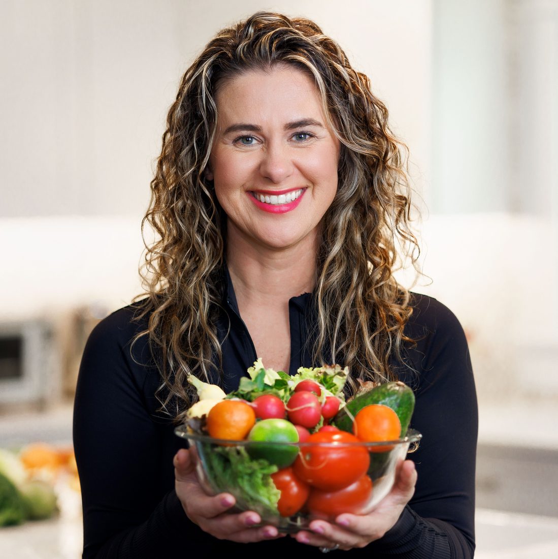 Personal branding portrait of a woman holding a bowl of fresh produce