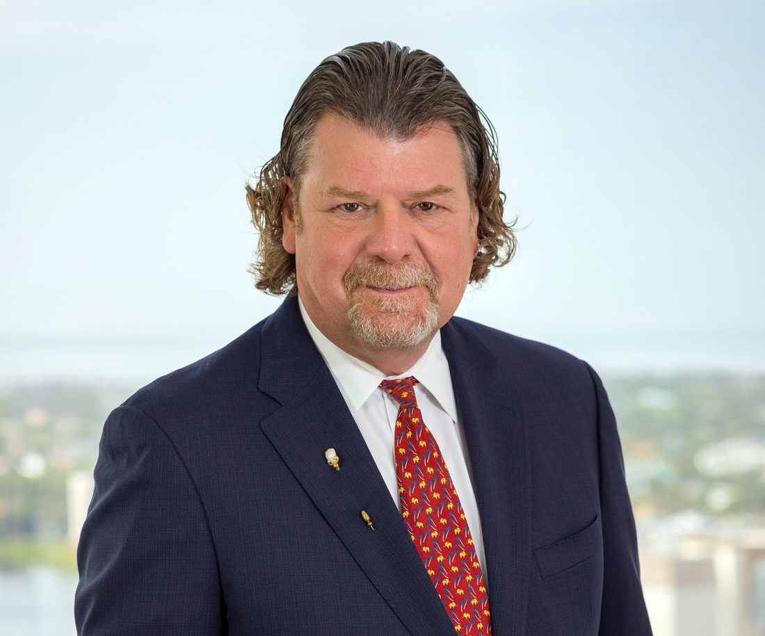 Business headshot of a man in a navy suit