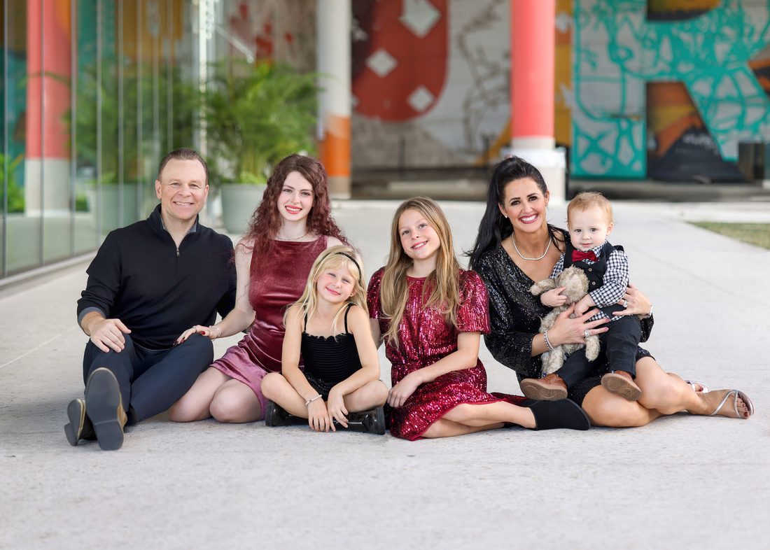 Family portrait in front of a colorful mural