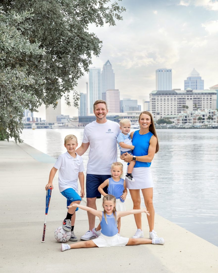 Family portrait by the water with the Tampa skyline